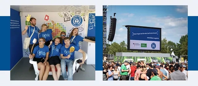 Gruppe junger Leute in T-Shirts mit dem Blauen Engel und eine große Leinwand mit Werbung für den Blauen Engel über den Festivalbesuchern